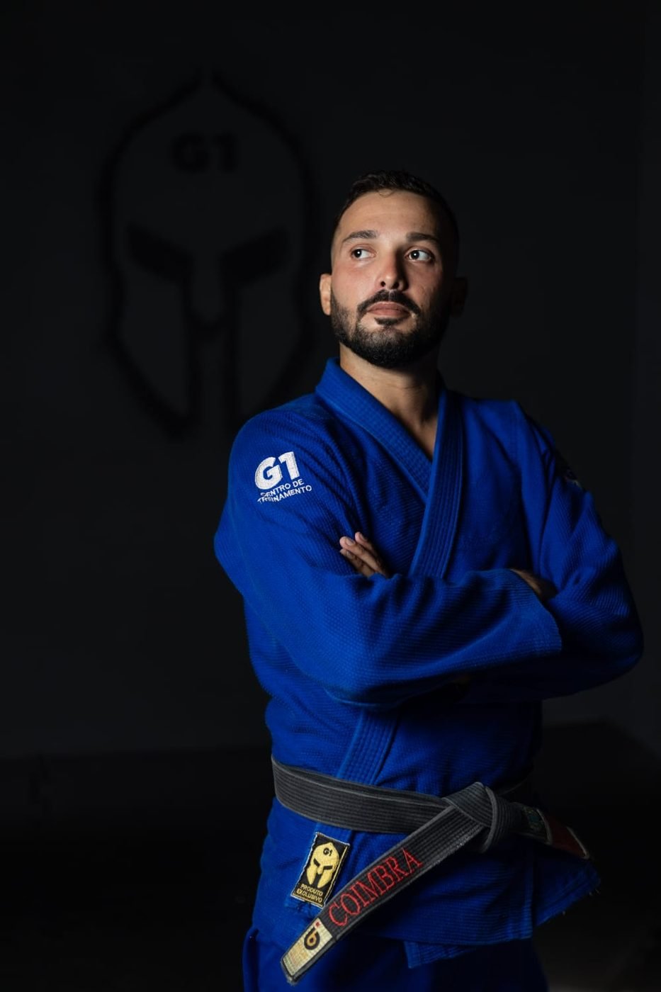 Retrato do professor Matheus Coimbra de braços cruzados, kimono azul e faixa preta
