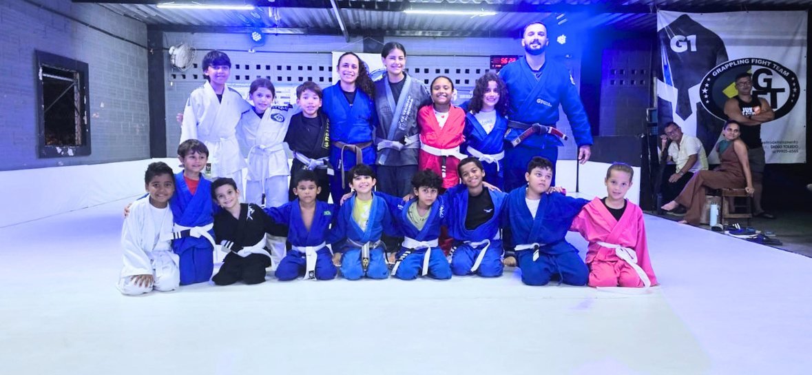 Turma de crianças reunida no tatame com o professor