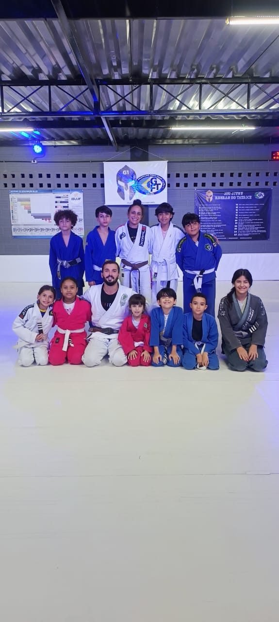 Turma infantil reunida no tatame com o professor